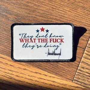May include: A rectangular patch with a black border and the text "They don't know WHAT THE FUCK they're doing" in red and blue. The patch includes three stars and a signature.