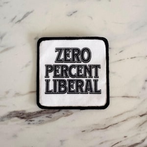 May include: White patch with black text that reads "ZERO PERCENT LIBERAL".