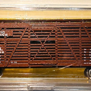 May include: A brown model train car with the text "ATLANTIC COAST LINE" and "ACL 140448" printed on the side. The model is in a clear plastic case with a price tag that reads "$ 4.75".