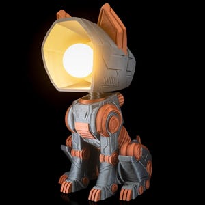 May include: A gray and orange robot dog lamp with a light on. The lamp is made of 3D printed plastic and has a futuristic design.
