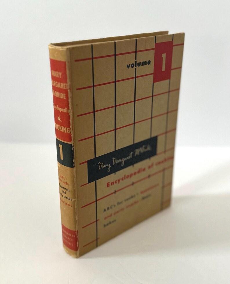 May include: Vintage cookbook, "Encyclopedia of Cooking, Volume 1" by Mary Margaret McBride. The book has a tan cover with a red and black grid pattern. The spine is red with white text. The title and author's name are visible.