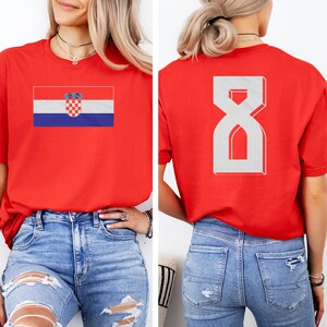 A woman wearing a red t-shirt with the Croatia national flag and the number 8 on the back.