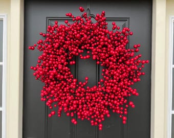 May include: A red berry wreath with a large number of berries, perfect for a holiday door decoration.