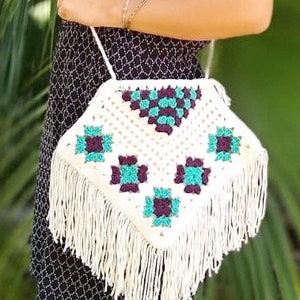 May include: White crocheted shoulder bag with a geometric pattern in teal and purple. The bag has a long fringe around the bottom.