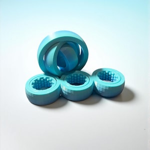 May include: A 3D-printed, light blue puzzle with a spherical top and three connected circular bases. Each base has a textured interior. The puzzle is designed with interlocking components and is set against a gradient blue and white background.