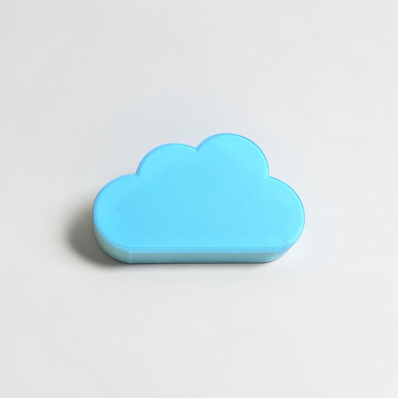 May include: A solid, light blue, cloud-shaped object with a smooth, matte finish. The item features a rounded, multi-lobed top edge and a flat base, presenting a simple, stylized representation of a cloud in a bright, uniform sky-blue color.