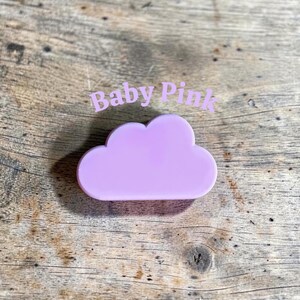 May include: A smooth, solid light purple cloud-shaped object with rounded edges. The text "Baby Pink" is printed in a light purple font above the cloud shape. The object has a flat surface and a uniform matte finish across its entire form.