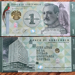Puede incluir: Dos billetes guatemaltecos de un Quetzal. El anverso del billete presenta un retrato de un hombre, el texto "Banco de Guatemala" y el número "1". El reverso del billete presenta un edificio y el texto "Cien Años De La Unidad Monetaria Quetzal".