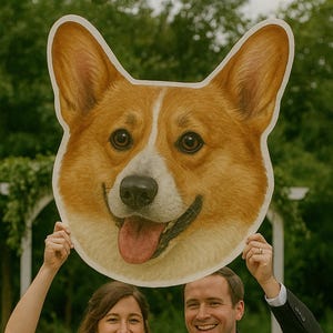 Könnte beinhalten: Ein lächelndes Paar hält einen großen, cartoonartigen Ausschnitt eines Corgi-Hunde-Gesichts hoch. Das Gesicht des Hundes ist braun, weiß und hellbraun, mit einer rosa Zunge. Die Frau trägt ein weißes Hochzeitskleid, der Mann einen schwarzen Anzug.