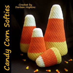 May include: Four crocheted candy corn softies in various sizes. The softies are white, orange, and yellow. The largest softie is about 10 inches tall. Crochet by Darleen Hopkins.