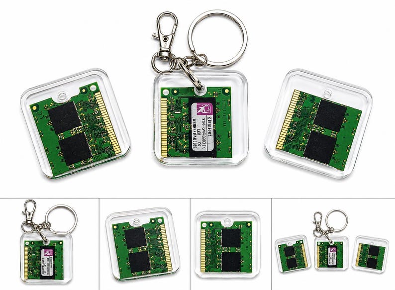 May include: A square clear acrylic keychain featuring a green computer RAM memory module embedded inside. The circuit board displays gold contact pins, black memory chips, and a white label with black text reading Kingston KTH-XW466/1G.