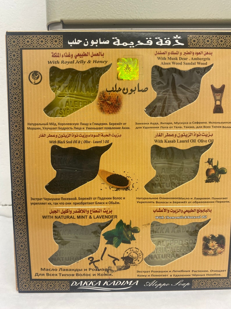 K&ouml;nnte beinhalten: Vier St&uuml;ck Naturseife mit verschiedenen Inhaltsstoffen und Vorteilen. Die Seifen sind in einer Schachtel mit arabischem Text und Bildern von Blumen und Kr&auml;utern verpackt. Der Text auf der Schachtel lautet "Daka Kadima Aleppo Soap".