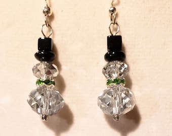 May include: A pair of silver snowman earrings with clear crystal beads, black beads for the hat, and green beads for the scarf.