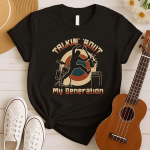 May include: Black t-shirt with a retro design featuring a musician playing guitar and the text "TALKIN' 'BOUT MY GENERATION". The shirt is paired with white sneakers and a ukulele.