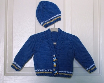 Suéter azul para bebé tejido a mano con gorro a juego con ribete amarillo y blanco y botones del Pato Donald