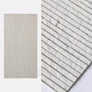 K&ouml;nnte beinhalten: Eine rechteckige Wandfliese in hellem Off-White mit einer strukturierten Oberfl&auml;che, die aus d&uuml;nnen, parallelen vertikalen Rippen besteht. Das Material hat ein mattes Finish mit einem leicht unebenen, natursteinartigen Erscheinungsbild.