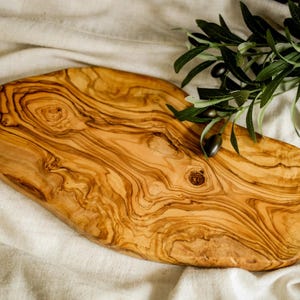 Reversible personalized cutting board crafted from premium olive wood. Ideal for slicing, dicing, or showcasing appetizers in style.