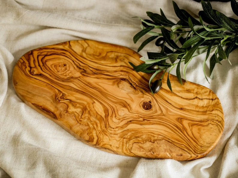 Reversible personalized cutting board crafted from premium olive wood. Ideal for slicing, dicing, or showcasing appetizers in style.
