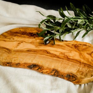 Unique olive wood cutting board personalized to order. Handmade from eco-friendly materials, perfect for rustic kitchen styling and gifting.