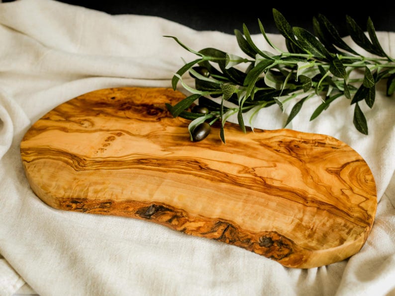 Unique olive wood cutting board personalized to order. Handmade from eco-friendly materials, perfect for rustic kitchen styling and gifting.
