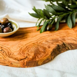 Natural olive wood board, engraved with a name or message. Doubles as a chopping surface and stylish serving platter for events and daily use.