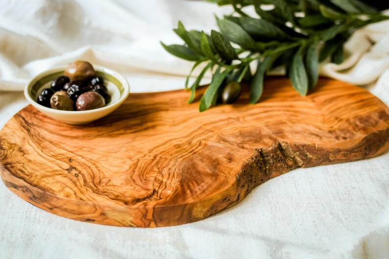 Natural olive wood board, engraved with a name or message. Doubles as a chopping surface and stylish serving platter for events and daily use.