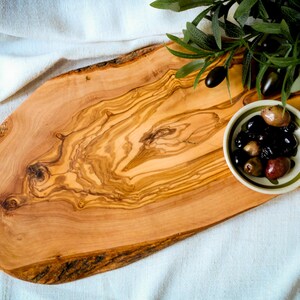 Custom olive wood kitchen board with juice groove and smooth finish. Durable, food-safe, and uniquely engraved for weddings or housewarmings.