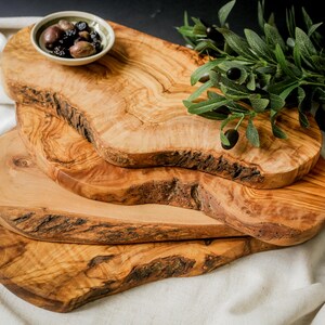 Personalized olive wood chopping board with natural grain, engraved for gifting. Ideal for food prep, charcuterie, or kitchen décor.