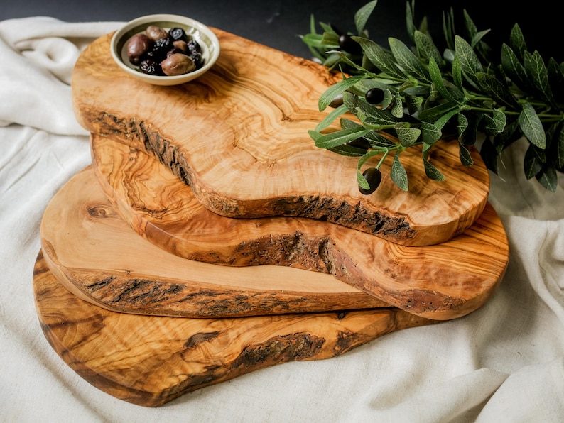 Personalized olive wood chopping board with natural grain, engraved for gifting. Ideal for food prep, charcuterie, or kitchen décor.