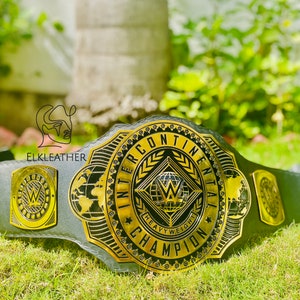 May include: A black and gold wrestling championship belt with the words "Intercontinental Heavyweight Champion" on the front. The belt has a large, gold "W" logo in the center.