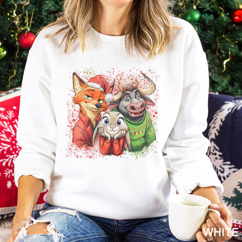 May include: White sweatshirt featuring a colorful graphic of three cartoon animals: a fox in a Santa hat, a bunny, and a bull. The graphic is decorated with red and green paint splatters, perfect for the holiday season.