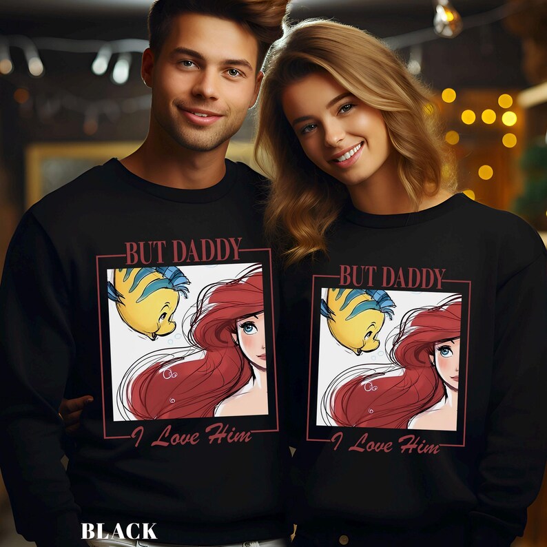 May include: Black sweatshirts with a graphic of Ariel and Flounder from The Little Mermaid, and the text "BUT DADDY - I Love Him". The sweatshirts are worn by a man and a woman.