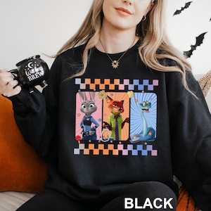 May include: Black sweatshirt featuring three cartoon characters in rectangular frames with a checkered border. The characters include a rabbit, a fox, and a snake. The word "BLACK" is printed at the bottom.