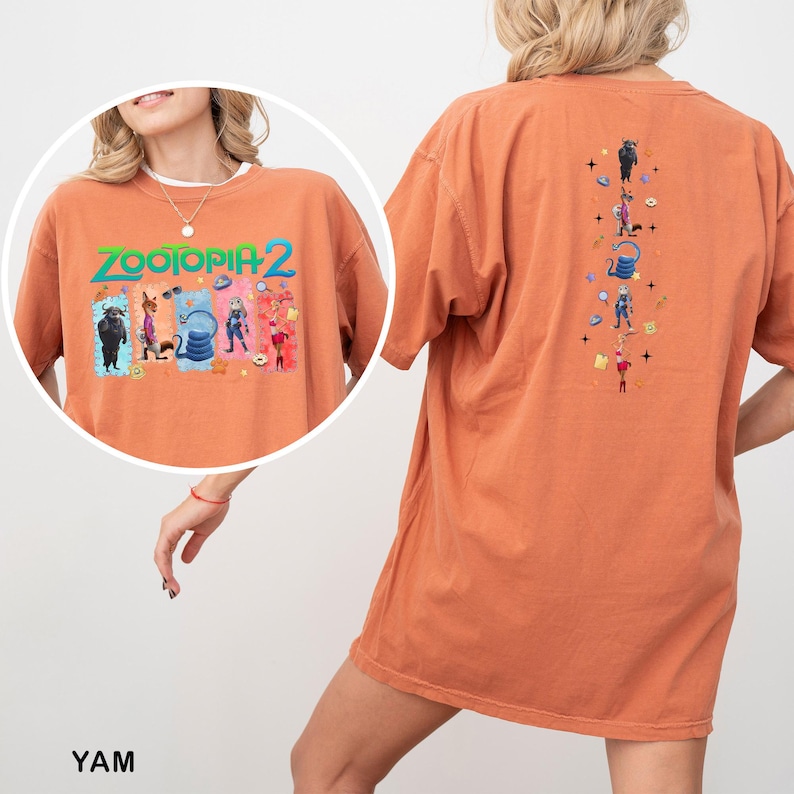 Op de afbeelding: Oranje T-shirt met korte mouwen met de tekst "ZOOTOPIA 2" en cartoonfiguren op de voorkant. De achterkant van het shirt heeft een verticaal ontwerp met meer cartoonfiguren. Het shirt is gemaakt van een zacht materiaal.