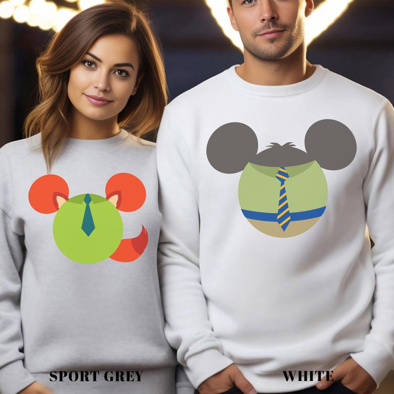 May include: Sport grey and white sweatshirts with cartoon mouse face designs. The sport grey sweatshirt features a green circle with orange ears and a blue tie. The white sweatshirt has a similar design with a green shirt and blue and yellow tie. The text "SPORT GREY" and "WHITE" are at the bottom.