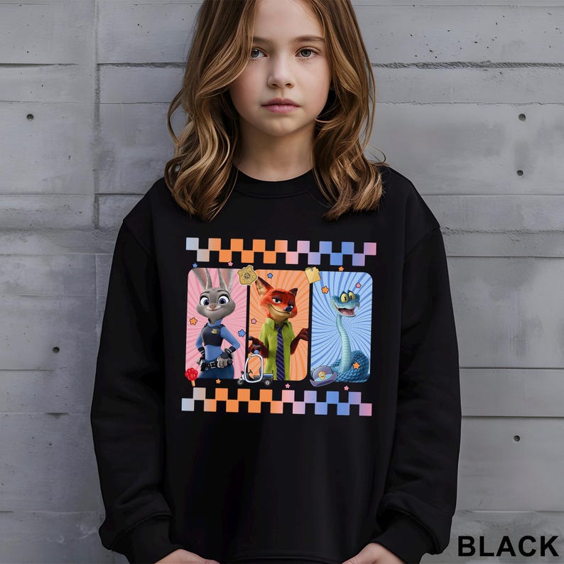 May include: Black sweatshirt featuring three cartoon characters: a rabbit in a police uniform, a fox in a green shirt, and a snake. The design is framed with a checkered pattern in orange, white, and blue. The word "BLACK" is printed at the bottom.