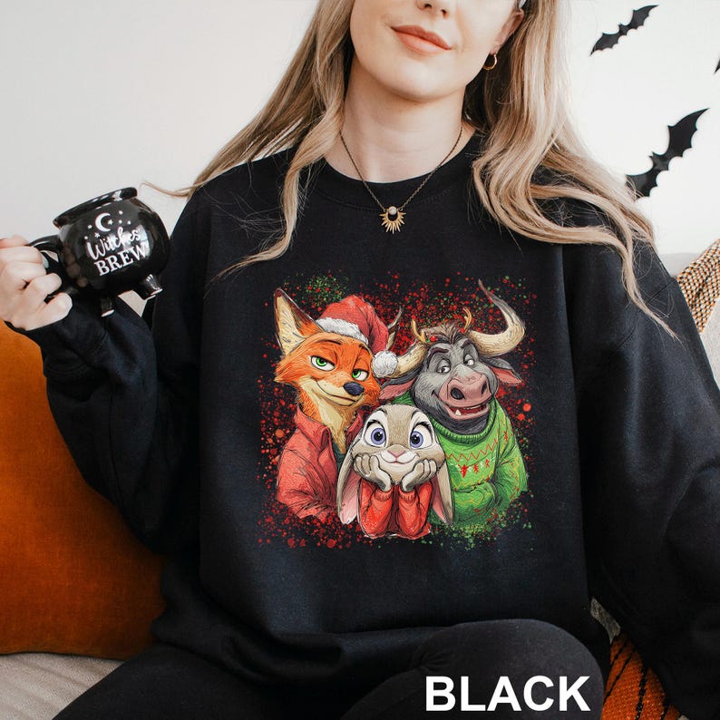 May include: Black sweatshirt featuring a colorful graphic of three cartoon characters: a fox in a Santa hat, a rabbit, and a bull wearing a green sweater. The word "BLACK" is printed at the bottom.