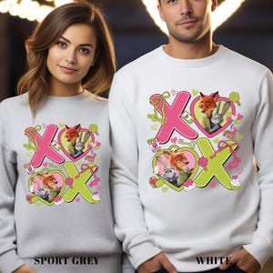 Peut inclure: Sweat-shirts gris sport et blancs avec un couple de renards et de lapins de dessin anim&eacute; &agrave; l'int&eacute;rieur de motifs "XO" roses et verts. Les sweat-shirts ont un col rond et des manches longues. Le texte "SPORT GREY" et "WHITE" est en bas.