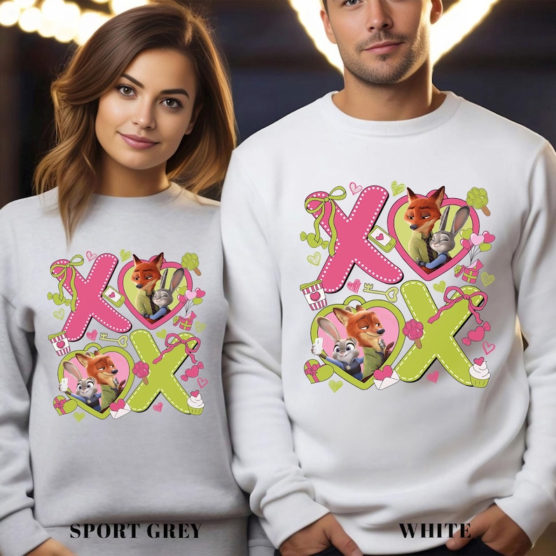 Peut inclure: Sweat-shirts gris sport et blancs avec un couple de renards et de lapins de dessin anim&eacute; &agrave; l'int&eacute;rieur de motifs "XO" roses et verts. Les sweat-shirts ont un col rond et des manches longues. Le texte "SPORT GREY" et "WHITE" est en bas.