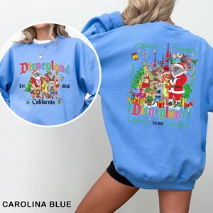 May include: Carolina blue sweatshirt with a Disneyland graphic on the front and back. The front graphic includes the Disneyland logo, characters, and the text "Est. 2016 California". The back graphic features the Disneyland logo and characters.