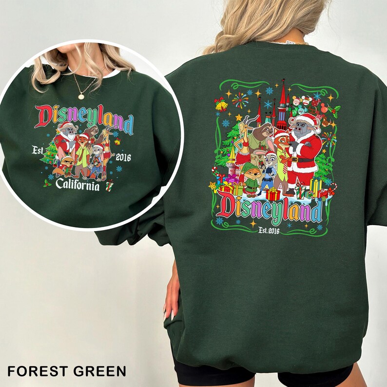 May include: Forest green sweatshirt with a Disneyland graphic. The front features a circular design with text and characters. The back has a larger graphic with the Disneyland logo, characters, and a castle. The sweatshirt is a crew neck.