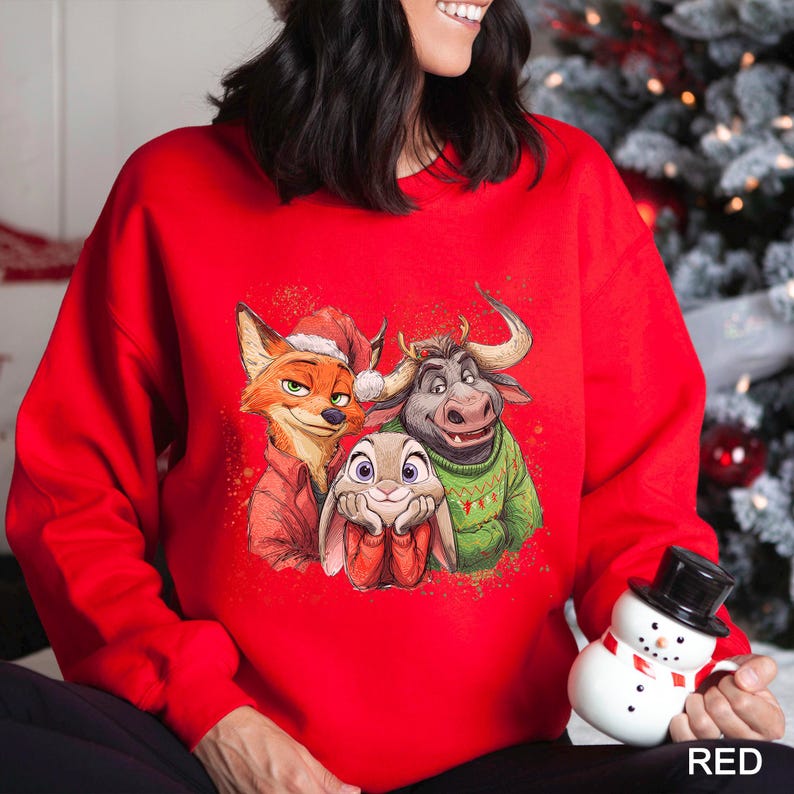 May include: A bright red sweatshirt featuring a graphic of three cartoon characters: a fox wearing a Santa hat, a bull in a green sweater, and a bunny. The word "RED" is printed in white at the bottom right.