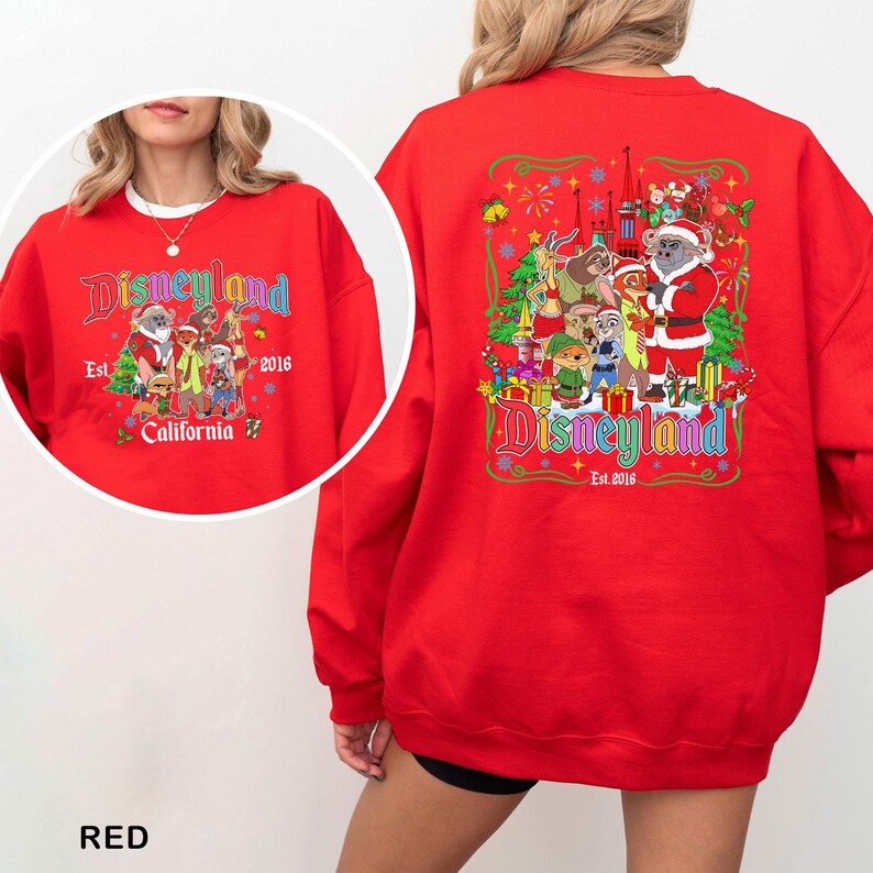 May include: A red Disneyland sweatshirt with a colorful graphic on the front and back. The front graphic includes the Disneyland logo, Santa Claus, and various cartoon characters. The back graphic features the Disneyland logo, Santa Claus, and other cartoon characters.