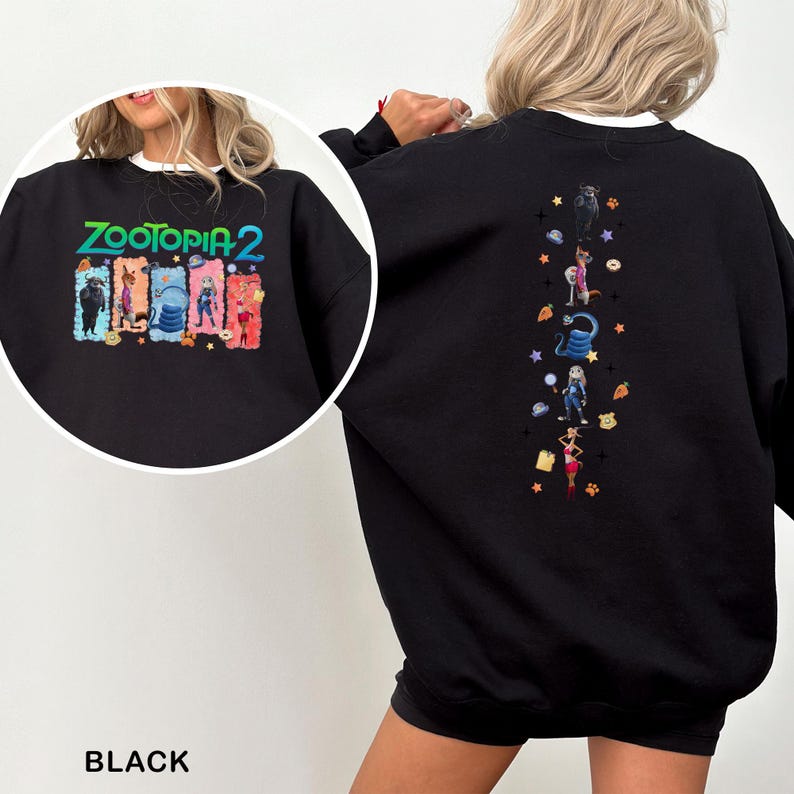 K&ouml;nnte beinhalten: Schwarzes Sweatshirt mit dem Text "ZOOTOPIA 2" in Gr&uuml;n, Gelb und Blau. Das Design auf der Vorderseite zeigt Zeichentrickfiguren. Die R&uuml;ckseite hat ein vertikales Design mit Zeichentrickfiguren und Sternen.