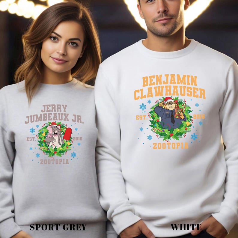 Pu&ograve; includere: Felpe grigio sport e bianche con personaggi di Zootopia. La felpa grigio sport ha il testo "Jerry Jumbeaux Jr." e un'immagine a cartoni animati. La felpa bianca ha il testo "Benjamin Clawhauser". Entrambe hanno il testo "Zootopia".