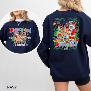 May include: Navy blue Disneyland sweatshirt with a colorful graphic featuring Disney characters in festive attire. The front displays "Disneyland" in a stylized font, with "Est. 2016" and "California" below. The back has a similar design.