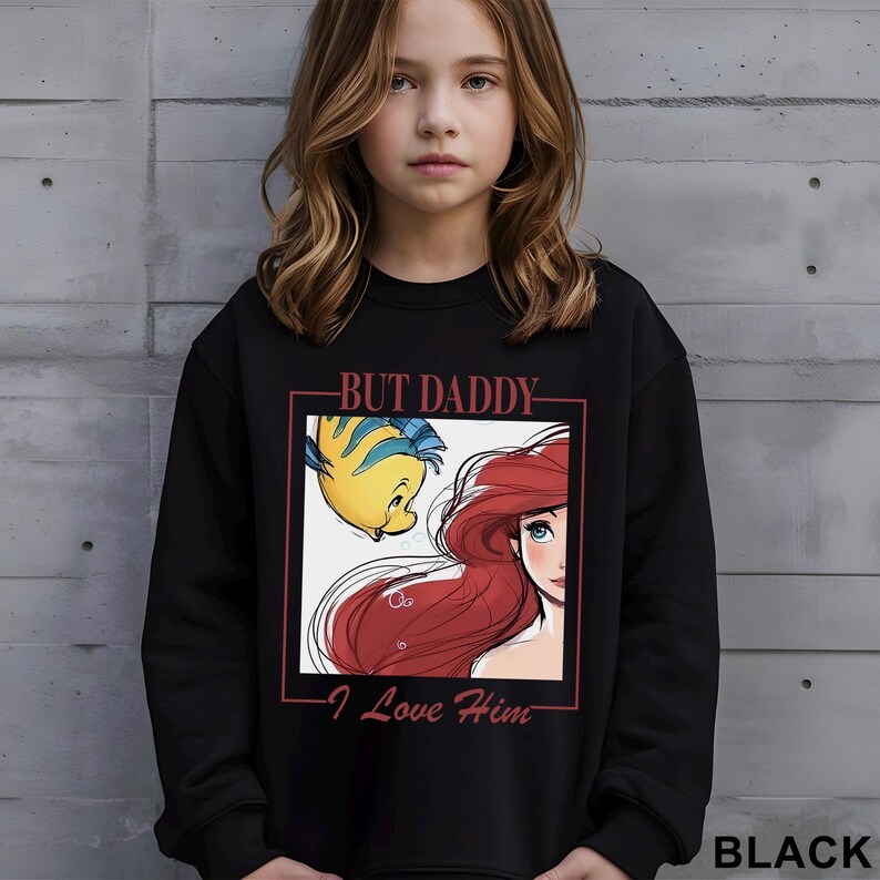 May include: Black sweatshirt with a graphic of Ariel and Flounder from The Little Mermaid, and the text "BUT DADDY I Love Him". The sweatshirt is black.