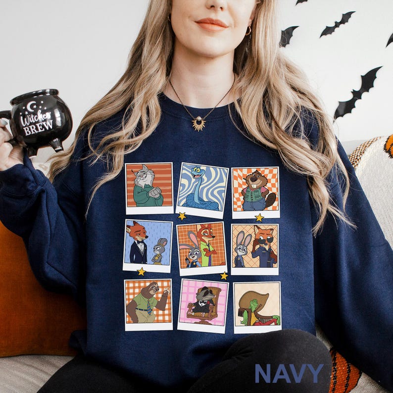 May include: Navy blue sweatshirt featuring a grid of cartoon character portraits in a polaroid style. The characters are anthropomorphic animals. The word "NAVY" is printed at the bottom. A black mug with the words "Witches Brew" is held in the upper left.