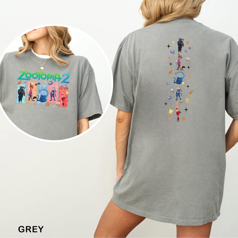 Op de afbeelding: Een grijs T-shirt met de tekst "ZOOTOPIA 2" en kleurrijke cartoonfiguren op de voorkant. De achterkant van het shirt heeft een verticaal ontwerp met meer cartoonfiguren. Het shirt is gemaakt van een zacht materiaal.
