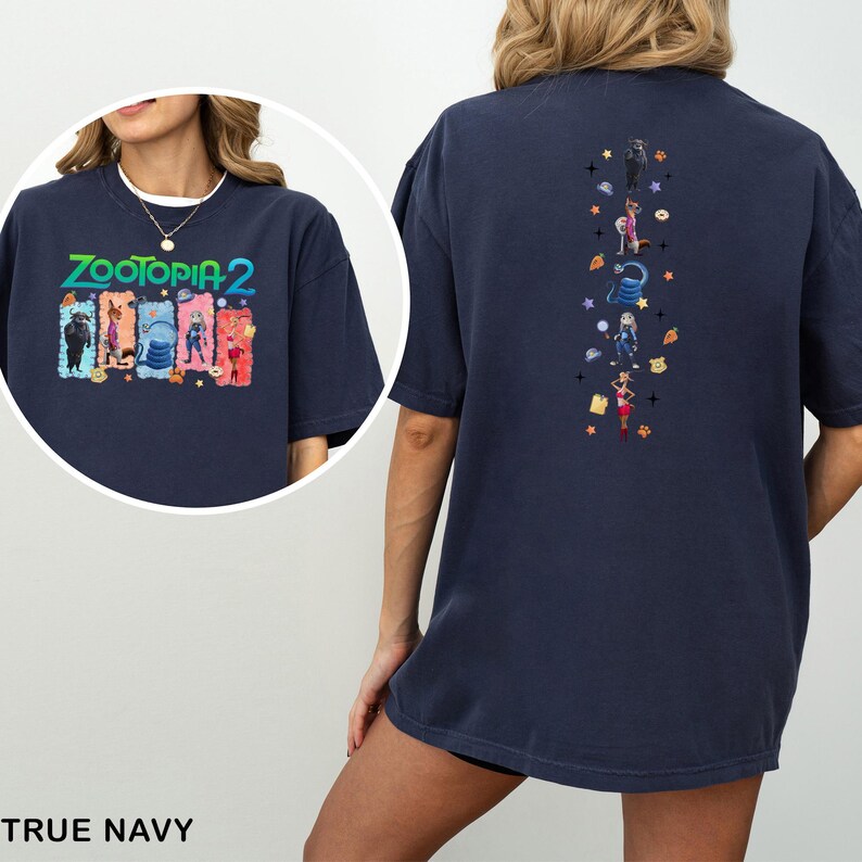 Op de afbeelding: Marineblauw T-shirt met de tekst "ZOOTOPIA 2" en karakterillustraties op de voorkant. De achterkant van het shirt heeft verticale illustraties van karakters en sterren.